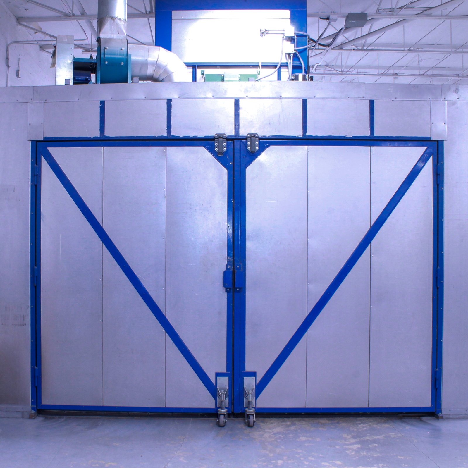 Large 20 foot curing oven, aluminum with blue accents on barn style doors.